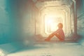 Backlight of a teenager depressed sitting inside a dirty tunnel Royalty Free Stock Photo