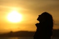 Backlight of woman silhouette breathing fresh air at sunset