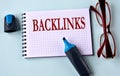 BACKLINKS - word on a white sheet with glasses and marker in the background Royalty Free Stock Photo