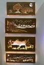 Backlit carved pictures of cows, mountain landscape and night landscape, made by LiGo company, displayed on creamy white wall