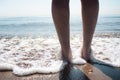 feet getting wet with the waves of the sea against the light Royalty Free Stock Photo