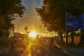 Backlit photography of a road intersection with the glowing sun in the background and the shadowy vehicles in the foreground