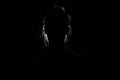 backlit portrait silhouette of unrecognizable woman hiding face and identy in the dark shadow Royalty Free Stock Photo