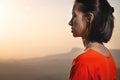 Backlit profile of a woman breathing deep fresh mountain air at morning sunrise or sunset. Calm happy woman with closed Royalty Free Stock Photo