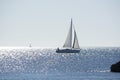 Backlit sailboat on bright and sunny sea with horizon Royalty Free Stock Photo