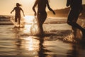 Backlit shot of teenagers running, having fun, playing and splashing water around them. At the beach during a sunny afternoon