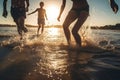 Backlit shot of teenagers running, having fun, playing and splashing water around them. At the beach during a sunny afternoon