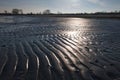 backlit shot of wet sand lines at the beach of the german city hohwacht