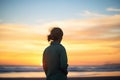 backlit silhouette of a person against a sunset on the beach