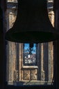 Backlit silhouette of two restored bronze bells from the tower of the Clerecia church with the view of the city of Salamanca from