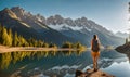 Backpack-adorned girl standing at edge of serene mountain lake