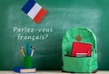 backpack, blackboard with text "parlez-vous franÃÂ§ais?", flag of the France, book and school supplies