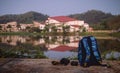 Backpack and a camera of a traveler photographer by the river