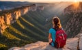 Backpack-clad girl poised at brink of panoramic cliff, gazing across vast canyon