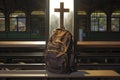A backpack and a cross on a platform of a train station. Missionary work