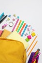 Backpack with different school stationery on white background, flat lay Royalty Free Stock Photo