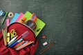 Backpack full of school supplies on green blackboard top view Royalty Free Stock Photo