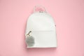 Backpack with grey faux fur keychain on pink background, top view Royalty Free Stock Photo