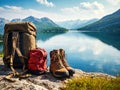 Backpack and hiking boots at the shore of beautiful scenic mountain lake Royalty Free Stock Photo