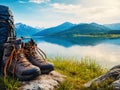 Backpack and hiking boots at the shore of beautiful scenic mountain lake Royalty Free Stock Photo