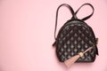 Backpack with leather keychain on pink background, top view. Space for text Royalty Free Stock Photo