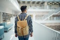 Backpack, library and study with a man student walking in a university bookstore for education or learning. Back