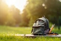 Backpack and pencils on the grass in the park at sunset, A school backpack in a field on a bright sunny day, AI Generated