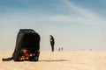 backpack placed on the white salt sand of the rann of kutchh with an indian girl standing in the distance Royalty Free Stock Photo