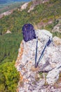 A backpack and Scandinavian sticks lie on a rock