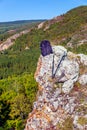 A backpack and Scandinavian sticks lie on a rock