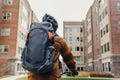 backpack on shoulders of student cycling past college dorms