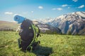 Backpack stands on top of a beautiful mountain, hiking, green valley