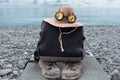 A backpack, a straw hat with glasses and an old sneaker lie by the seashore Royalty Free Stock Photo
