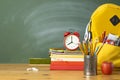 Backpack, textbooks, stationery and school supplies on wooden desk