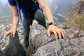 backpacker climbing rock on mountain top cliff edge Royalty Free Stock Photo