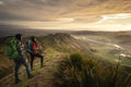 Backpacker couple standing at the peak of a mountain looking at the horizon Royalty Free Stock Photo