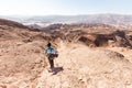 Backpacker descending hiking mountain ridge stone desert landscape Royalty Free Stock Photo