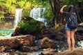 Young beautiful woman in bikini explore waterfall hidden in the tropical jungle on background amazing wild tropical nature