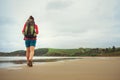 Backpacker girl traveler walk on deserted ocen beach Royalty Free Stock Photo