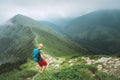 Backpacker hiker man walking by the foggy cloudy weather mountain range path with backpack. Active sport backpacking healthy Royalty Free Stock Photo