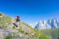 Backpacker hiking on the Alps, majestic Mont Blanc in background Royalty Free Stock Photo