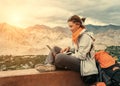 Backpacker with laptop sits on the top view point under mountain Royalty Free Stock Photo