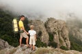 Backpacker with little son in the foggy mountains.