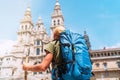 Backpacker man pilgrim looking at Santiago de Compostela Cathedral standing on the Obradeiro square plaza - the main square in