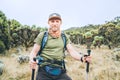 Backpacker man portrait having a hiking walk with trekking poles on the Umbwe route in the forest to Kilimanjaro mountain. Active