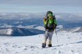 Backpacker man is posing in winter mountains