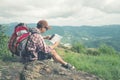 Backpacker man searching right direction on map.