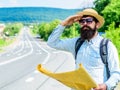 Backpacker man travelling by hitchhiking on his own. What is there. Tourist with map see familiar landmark. Seems