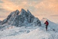 Backpacker mountaineer hiking on snow hill with majestic mount w