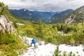 Backpacker mountaineer looking at snow covered mountains forest